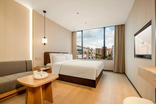 um quarto de hotel com uma cama e um sofá em Relax Hotel - Shenzhen Bao'an International Airport em Bao'an