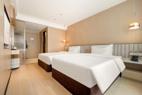 a large white bed in a hotel room at Relax Hotel - Shenzhen Bao'an International Airport in Bao'an