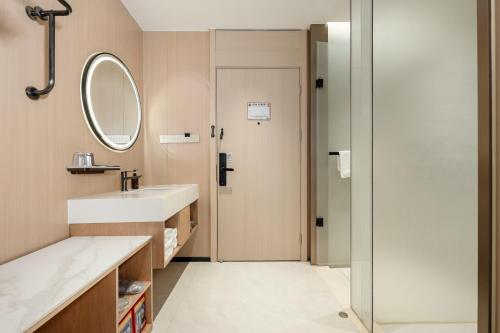 a bathroom with a sink and a mirror at Relax Hotel - Shenzhen Bao'an International Airport in Bao'an
