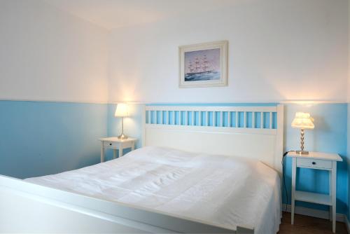 a blue bedroom with a white bed and two tables at Albatros in Stein
