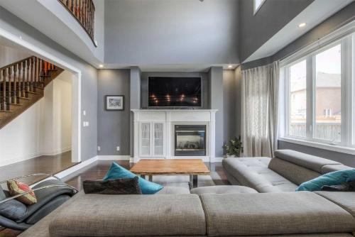 a living room with a couch and a fireplace at Elegance: Luxurious Stay in the Heart of Community in Brampton