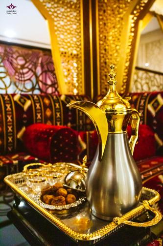 a tea kettle on a table with a tray of food at Violet Al Azizia Hotel MASJID Al Qatari in Makkah