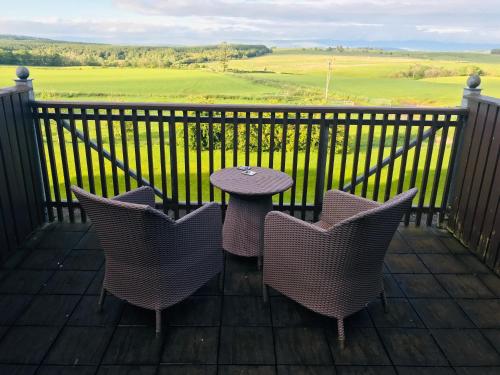 d'une table et de chaises sur un balcon avec vue sur un champ. dans l'établissement Bowscale Suite, à Penruddock