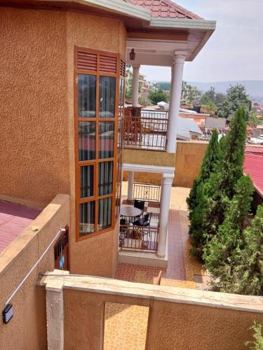 un balcón de una casa con mesa y sillas en CONVENTION VILLA APART HOTEL, en Kigali