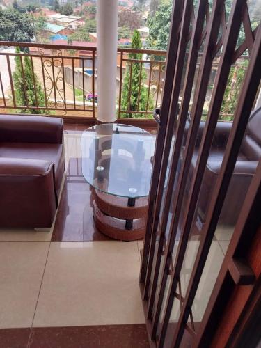 a living room with a glass table on a balcony at CONVENTION VILLA APART HOTEL in Kigali