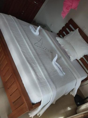 Una cama con sábanas blancas y almohadas. en CONVENTION VILLA APART HOTEL, en Kigali
