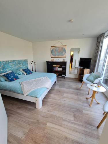 a bedroom with a bed and a living room at Bed & Breakfast de Koepeltjes in Zoetermeer