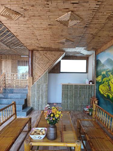 a room with benches and a table and stairs at Hill House in Mai Chau
