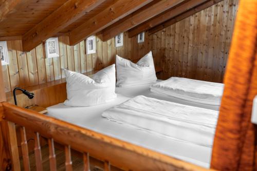 two beds in a wooden room with white pillows at Bahnhöfle Ferienhaus in Stubersheim