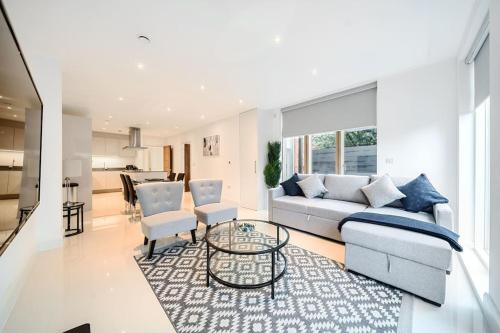 a living room with a couch and chairs and a table at Amazing 3 Bedroom Flat in the Heart of Wimbledon in London