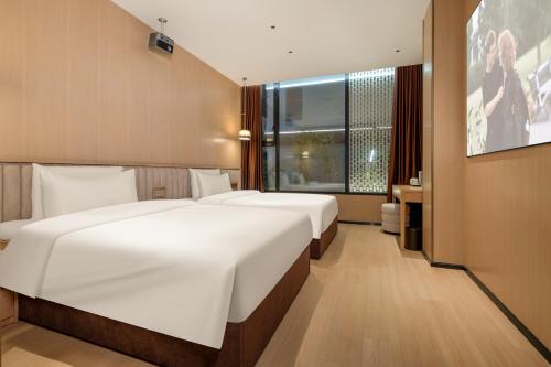 a hotel room with two beds and a large window at Relax Hotel - Shenzhen Bao'an International Airport in Bao'an