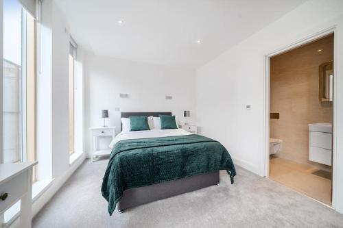 a white bedroom with a bed and a bathroom at Amazing 3 Bedroom Flat in the Heart of Wimbledon in London