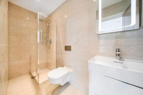 a bathroom with a toilet and a shower and a sink at Amazing 3 Bedroom Flat in the Heart of Wimbledon in London