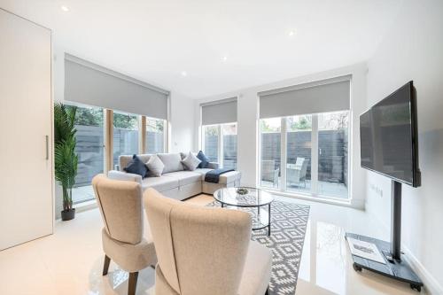 a living room with a couch and a tv at Amazing 3 Bedroom Flat in the Heart of Wimbledon in London