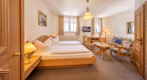 ein Schlafzimmer mit einem Bett und ein Wohnzimmer in der Unterkunft Waldgasthof Wildbad in Burgbernheim