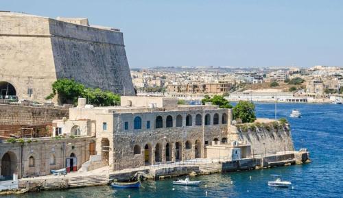 a large stone building next to a body of water at Spacious 2BR home with Large, Private Sun Terrace by 360 Estates in Taʼ Xbiex