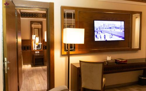 a hotel room with a television on a wall at Violet Al Azizia Hotel MASJID Al Qatari in Makkah