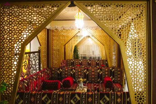 a room with red chairs and a chandelier at Violet Al Azizia Hotel MASJID Al Qatari in Makkah