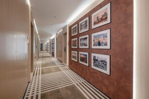 a hallway with a row of pictures on a wall at Relax Hotel - Shenzhen Bao'an International Airport in Bao'an