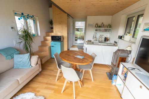 a kitchen and living room with a table and chairs at Tiny House Chez Claudine with Garden, Workspace, Netflix, free Parking & Wifi in Brugg