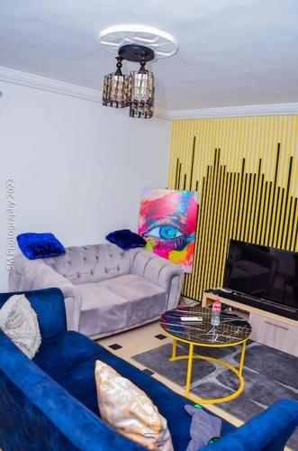 a living room with a blue couch and a table at Sweet and cozy in Cotonou