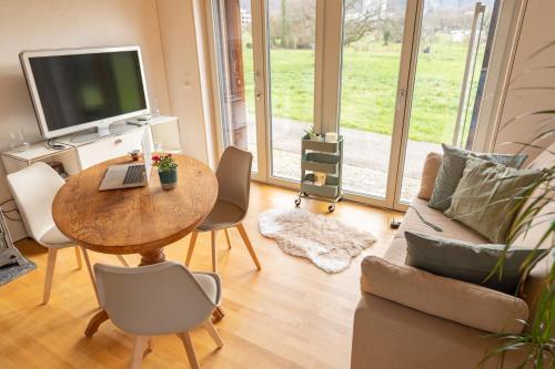 sala de estar con mesa y TV en Tiny House Chez Claudine with Garden, Workspace, Netflix, free Parking & Wifi en Brugg