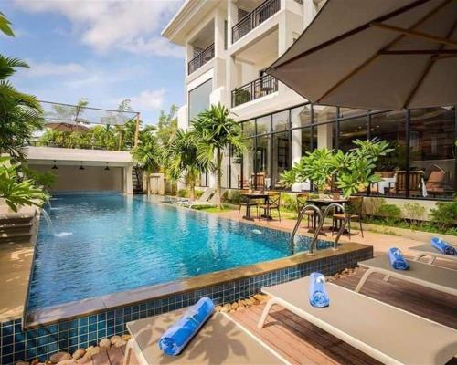 een zwembad voor een gebouw bij Angkor Style Resort & Spa in Phumĭ Ta Phŭl