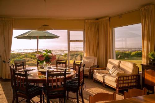 a living room with a table and a couch at Seafront Family Getaway, Vermont in Hermanus