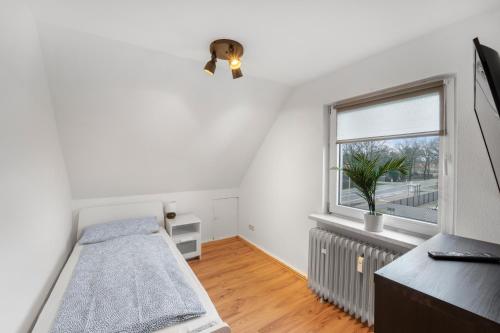 um quarto com uma cama e uma janela em Gemütliche Wohnung mit Küche in ruhiger Lage em Adelheidsdorf