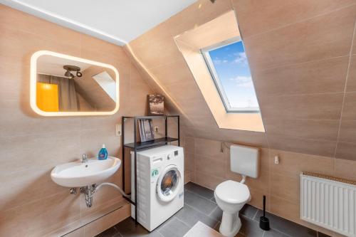 uma casa de banho com uma máquina de lavar roupa e um lavatório em Gemütliche Wohnung mit Küche in ruhiger Lage em Adelheidsdorf