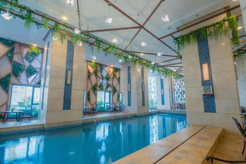 a large swimming pool with blue water in a building at Violet Al Azizia Hotel MASJID Al Qatari in Makkah