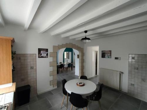 une salle à manger avec une table et des chaises blanches dans l'établissement *Gîte Aux Grappes du Pressoir* à 2 km de Beauval, à Seigy