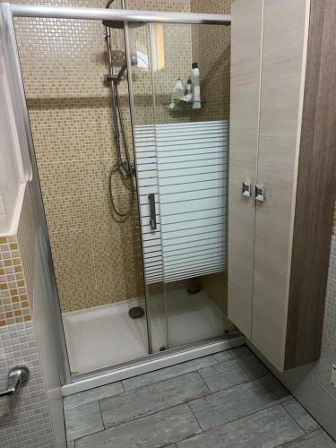 La salle de bains est pourvue d'une douche avec une porte en verre. dans l'établissement Appartamento Via Milano Prato, à Prato