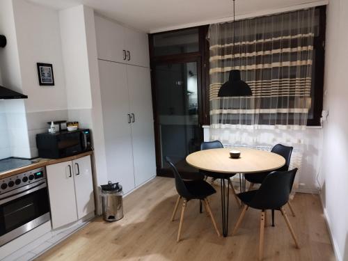 a kitchen with a table and chairs in a room at Home apartment in Niš