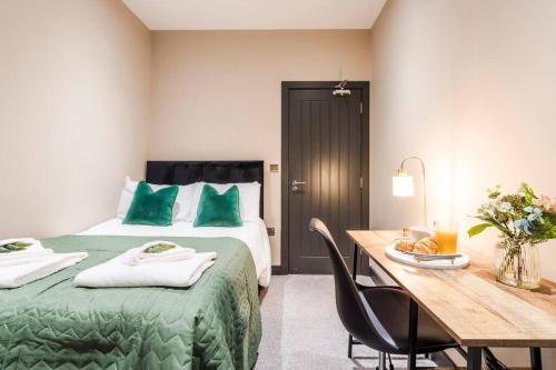 1 dormitorio con cama verde y mesa de madera en Wiverton Apt #2 - Central Location - Free Parking, Fast WiFi and Smart TV by Yoko Property, en Nottingham
