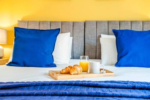 a tray of croissants and a glass of orange juice on a bed at Brook Retreat - City Centre - Free Parking, Fast WiFi and Smart TV by Yoko Property in Derby