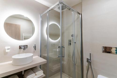 a bathroom with a glass shower and a sink at Spa & Wellness Hotel Fitak**** in Liptovský Ján