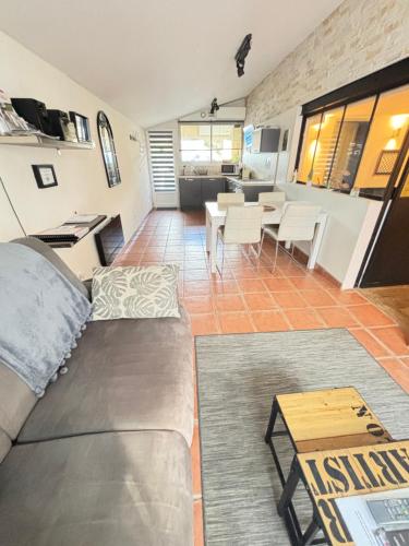 ein Wohnzimmer mit einem Sofa und einem Tisch in der Unterkunft appart central et son parking privatif gratuit in Collioure