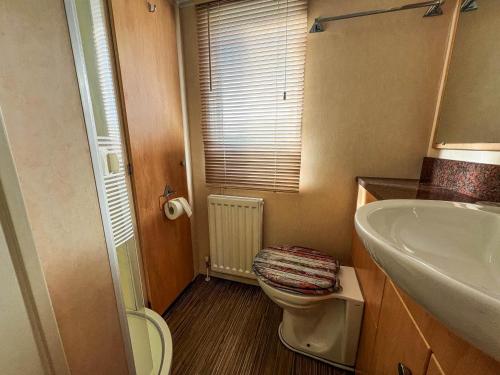 a bathroom with a toilet and a sink at Great Caravan For Hire With Pond Views At Manor Park Holiday Park Ref 23228k in Hunstanton