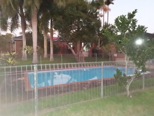 una valla alrededor de una piscina con palmeras en El Seuno de África -The dream of Africa en St Lucia