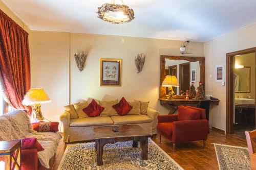 Monte Bianco Villas في أراخوفا: غرفة معيشة مع أريكة وكرسي