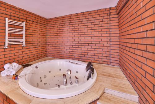 a bath tub in a room with a brick wall at Agva Teras Garden Hotel & Bungalow in Agva