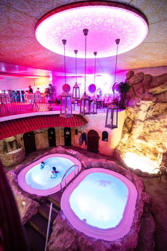 a hot tub in a room with a rock wall at Hotel Azzun Orient SPA&Wellness in Kromerowo