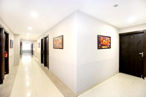 un pasillo con paredes blancas y una puerta negra en OYO Hotel Karma, en Jalandhar