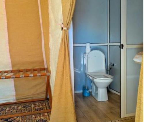 a small bathroom with a toilet in a room at Merzouga luxury magic nights in Merzouga