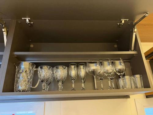 a row of wine glasses sitting on a shelf at Loft lindo de alto padrão in Capão da Canoa