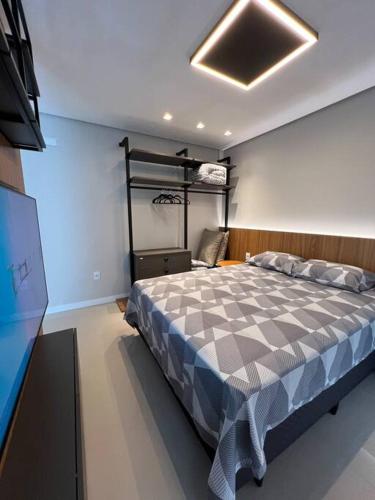 a bedroom with a large bed and a television at Loft lindo de alto padrão in Capão da Canoa