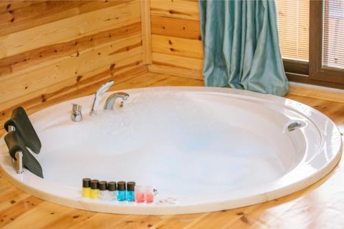 a large white tub in a room with wooden floors at Agva Teras Garden Hotel & Bungalow in Agva