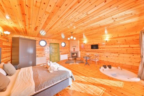 a bedroom with a wooden ceiling with a bed and a tub at Agva Teras Garden Hotel & Bungalow in Agva