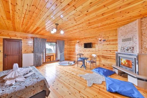 a log cabin room with a bed and a fireplace at Agva Teras Garden Hotel & Bungalow in Agva